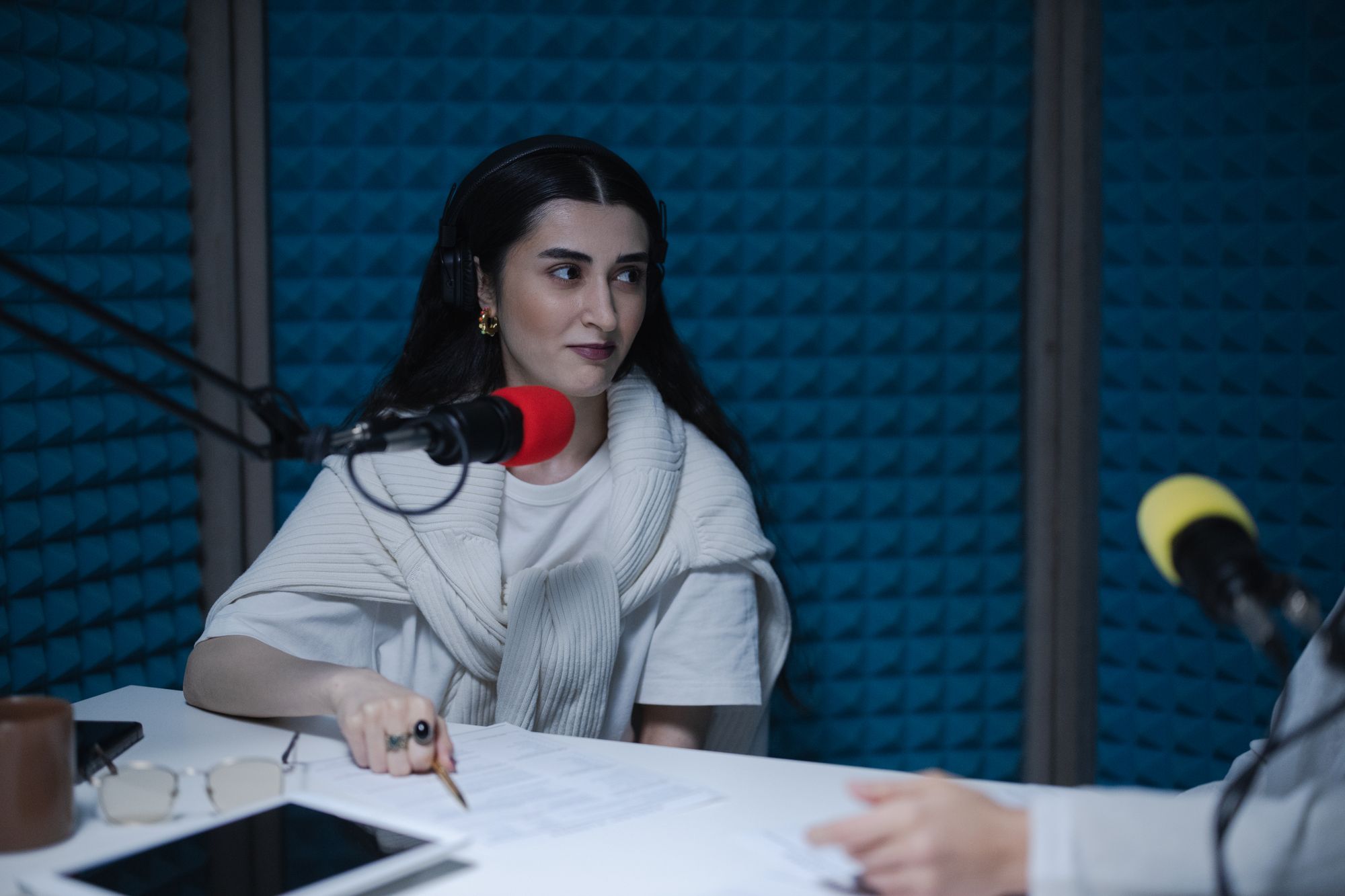 Una podcaster davanti al microfono in uno studio insonorizzato