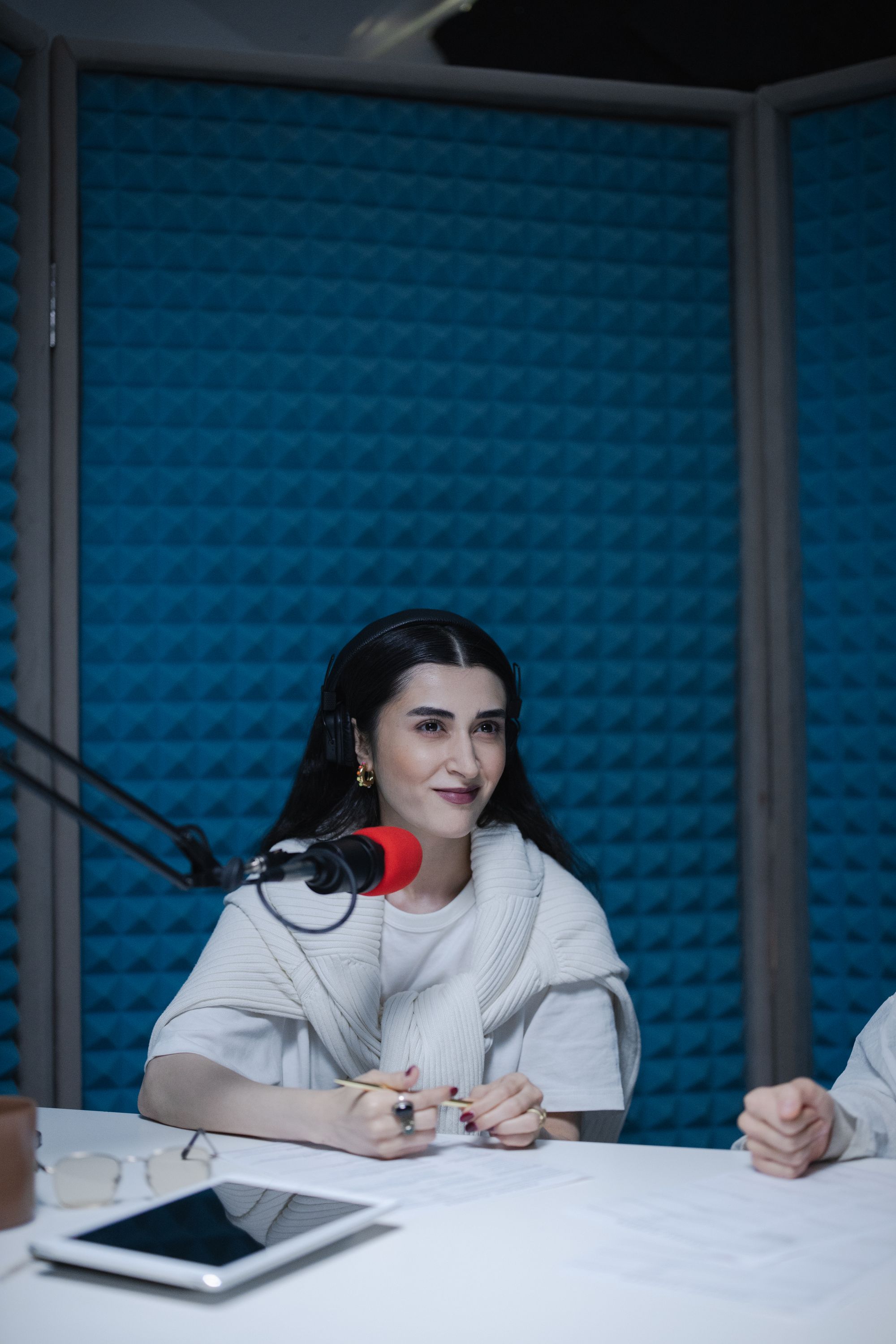 Una relatrice al microfono in uno studio blu